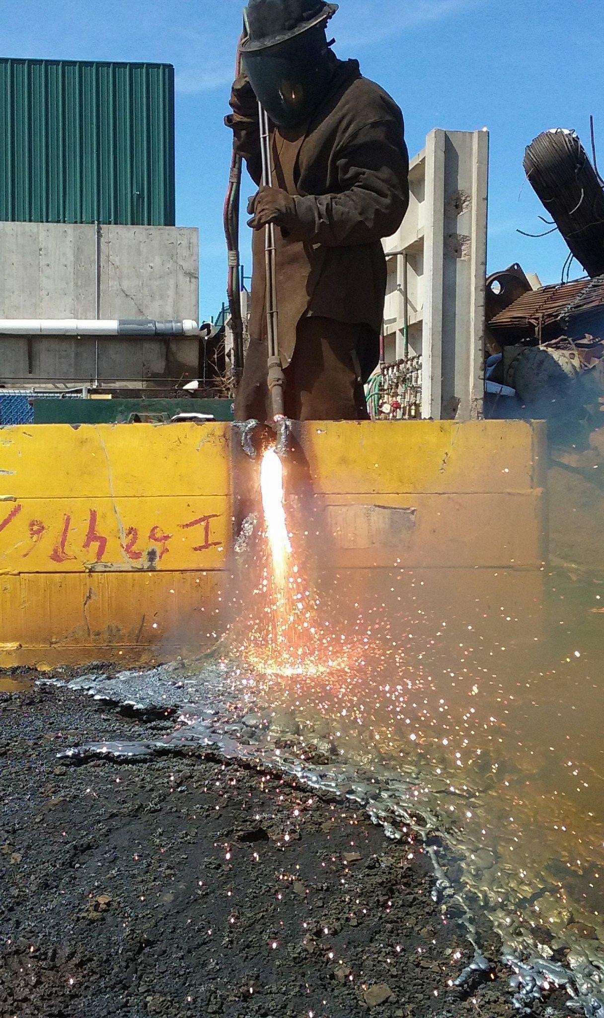 Torch operator cutting heavy yellow steel